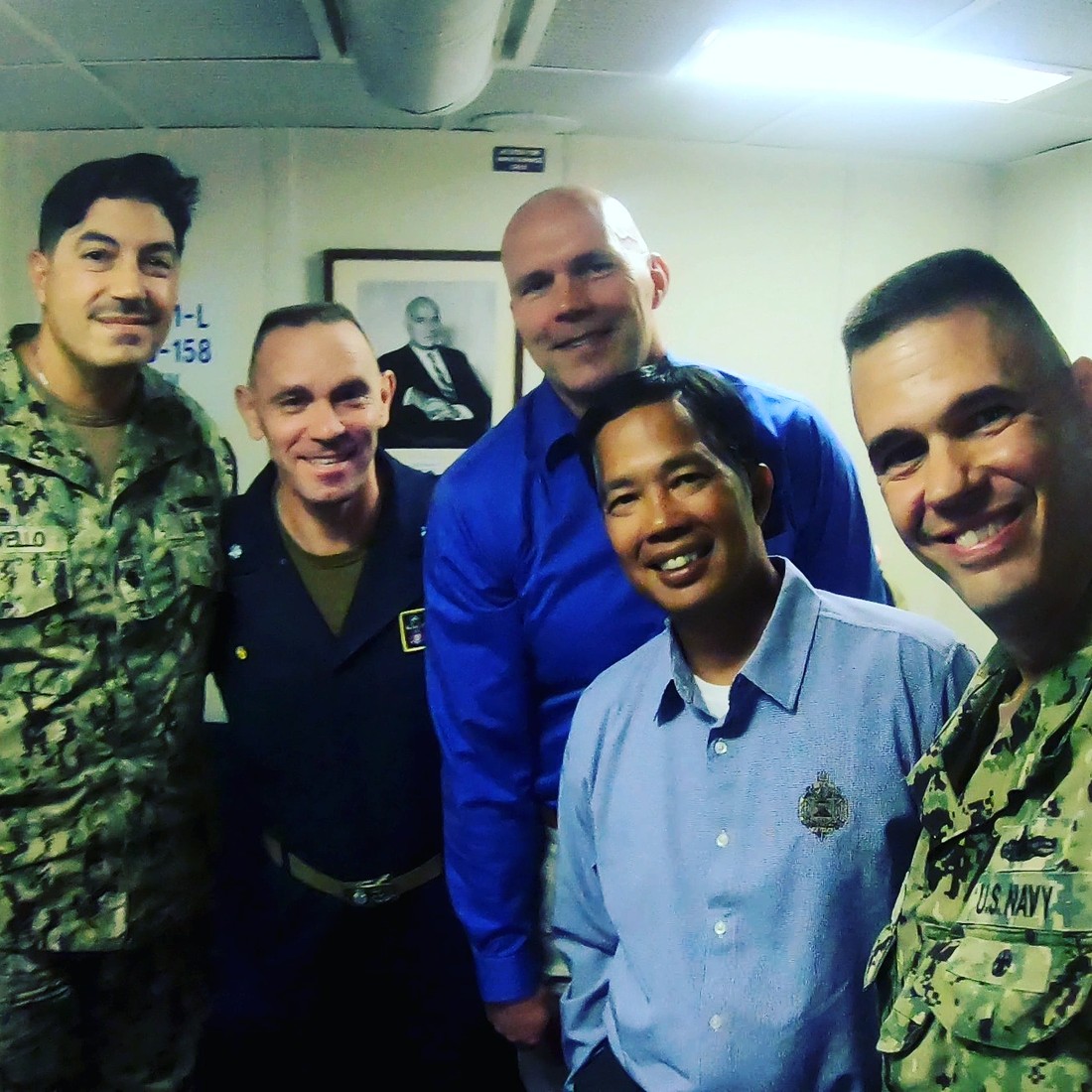Wes with fellow service members, smiling together indoors.